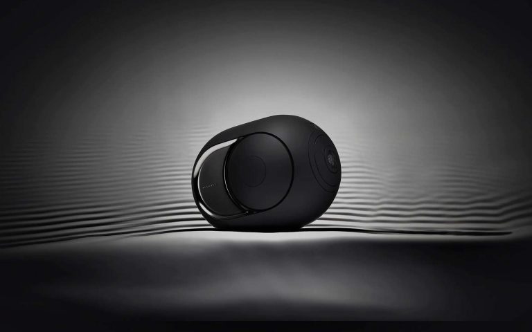 Altavoz moderno y elegante en tonos oscuros, con un diseño futurista que destaca en un fondo minimalista.